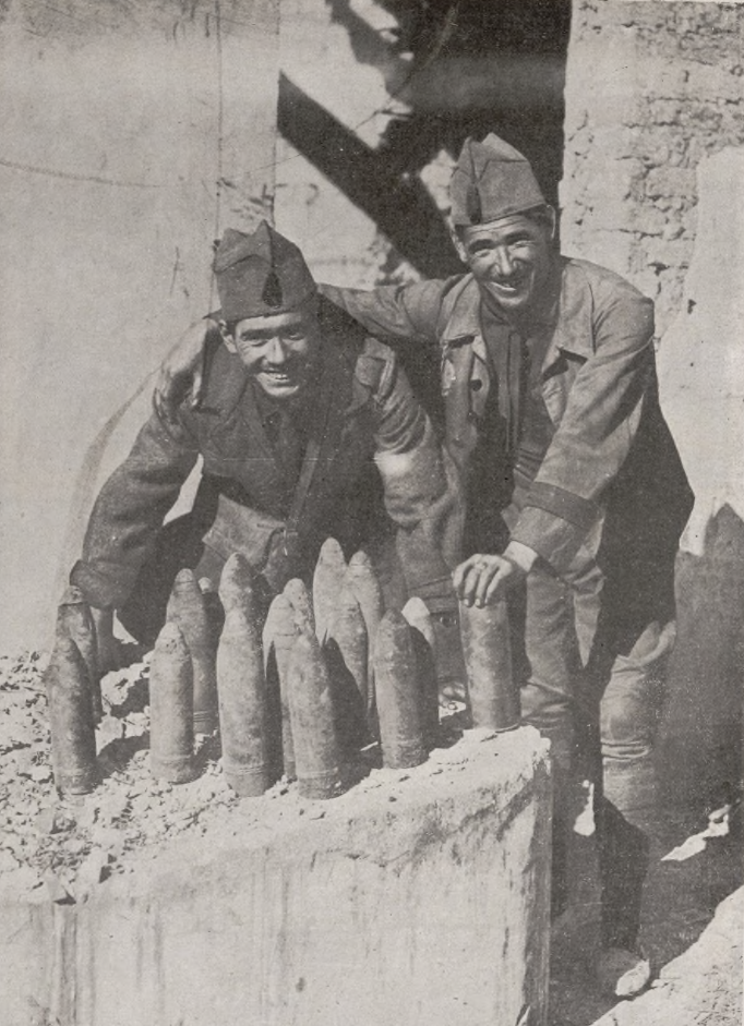 Dos-soldados-del-Tercio-muestran-las-granadas-toamdas-a-los-rifenos-tras-dar-muerte-a-los-artilleros-de-una-posicion-artillera-Alhucemas